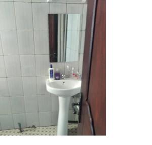 a bathroom with a sink and a mirror at Appartements meublés Sorel in Douala