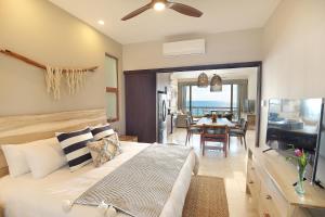um quarto com uma cama e uma sala de jantar em Hear the waves! Amazing beachfront condo with unbeatable views! em San José del Cabo