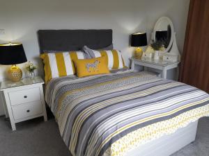 a bedroom with a bed with yellow pillows and lamps at Clumber Lane End Farm in Worksop