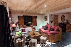 a living room with a couch and a table at Le Chalet De Thalie in Bourg-Saint-Maurice