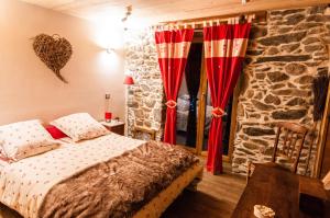 - une chambre avec un lit et un mur en pierre dans l'établissement Le Chalet De Thalie, à Bourg-Saint-Maurice