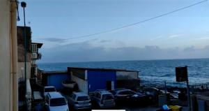 un gruppo di auto parcheggiate vicino all'oceano di Cala Volta Comfort House a Torre del Greco