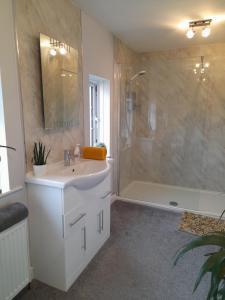 a bathroom with a white sink and a shower at Clumber Lane End Farm in Worksop