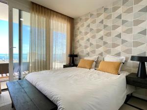 1 dormitorio con cama grande y ventana grande en Bayview -Superb Luxurious Sea View Penthouse with private hot tub by Solrentspain en Benalmádena