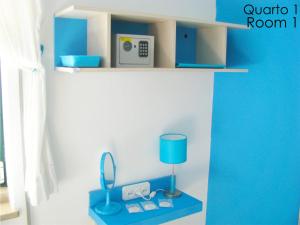 Habitación con estante azul con lámpara y espejo en Tiago & Jorge Guesthouse, en Nazaré