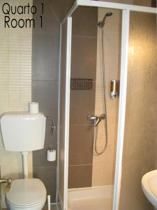 y baño con ducha, aseo y lavamanos. en Tiago & Jorge Guesthouse, en Nazaré