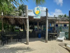 un restaurante en la playa con mesas y sillas en Espaço Revive Guesthouse e Camping - PÉ NA PRAIA, en Maragogi