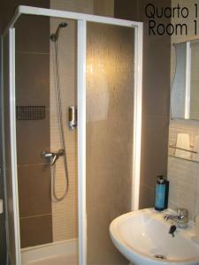 y baño con ducha y lavamanos. en Tiago & Jorge Guesthouse, en Nazaré