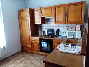 uma cozinha com armários de madeira e um forno com placa de fogão em LA PETITE MAISON em Saint-Loup-Géanges