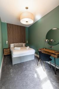 a bedroom with a bed and a desk and a mirror at Ty Belgrave - Apartment 2 in Aberystwyth