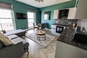a kitchen and living room with a couch and a table at Ty Belgrave - Apartment 2 in Aberystwyth