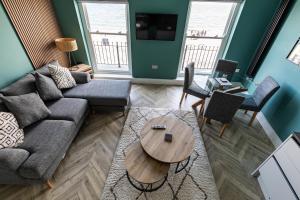 a living room with a couch and a table at Ty Belgrave - Apartment 2 in Aberystwyth