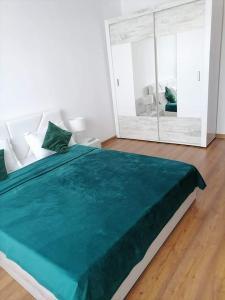 Cama verde grande en habitación con ventana grande en Casa Regala EAR, en Craiova