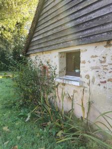 a window on the side of a stone building at "Rêves de Gamins" Chambre de gauche, 4 couchages dans gîte de campagne "La Camusière", proche du Pôle Européen et du circuit des 24h in Champagné