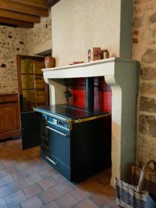 a kitchen with a stove with a counter top at "Rêves de Gamins" Chambre de gauche, 4 couchages dans gîte de campagne "La Camusière", proche du Pôle Européen et du circuit des 24h in Champagné