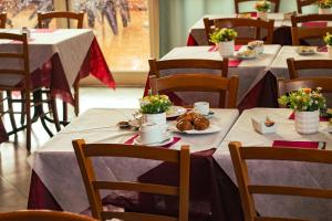 a dining room with tables with flowers on them at Hotel Garden Napoli in Naples