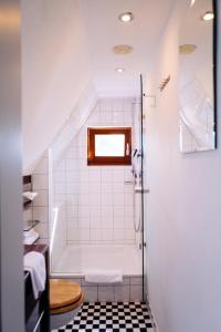 ein Bad mit einer Dusche und einem WC in der Unterkunft Lint Hotel Köln in Köln
