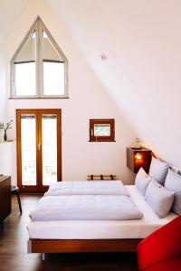 a white bedroom with two beds and a window at Lint Hotel Köln in Cologne