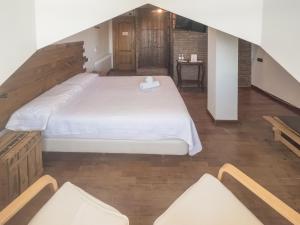 Schlafzimmer mit einem großen weißen Bett und Holzböden in der Unterkunft El Balcon de las Nieves in La Zubia