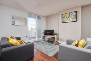 een woonkamer met 2 banken en een televisie bij Central Manchester 2 Bed - Parking - Sleeps 4 in Manchester