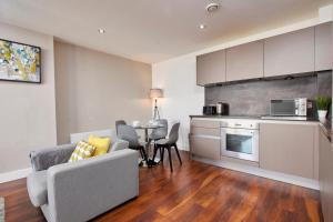 a kitchen and a living room with a couch and a table at Central Manchester 2 Bed - Parking - Sleeps 4 in Manchester