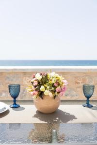 un vaso pieno di fiori seduto su un tavolo di Elaianthos 2 a Gythio