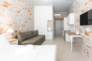 a room with a bed and a couch and a kitchen at Elaianthos 2 in Gythio