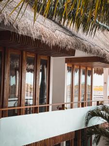 a building with windows and a thatched roof at Hotel Casa Margot in Holbox Island