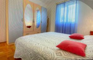Schlafzimmer mit einem Bett mit zwei roten Kissen und Surfbrettern in der Unterkunft Apartman Hola in Novigrad Istria + 31 Fotos
