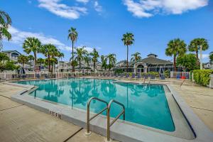 een groot zwembad met palmbomen en huizen bij Siesta Bayside Condo in Siesta Key