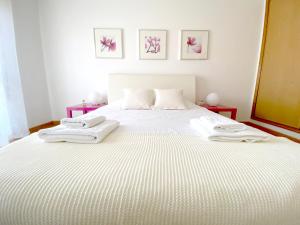 ein Schlafzimmer mit einem weißen Bett und Handtüchern darauf in der Unterkunft Apartment Castelo Branco - Portugal in Castelo Branco