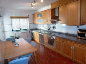 a kitchen with wooden cabinets and a wooden table at Apartment Castelo Branco - Portugal in Castelo Branco