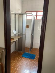a bathroom with a shower with a blue rug at Pousada Casa de Bragança in Bragança Paulista