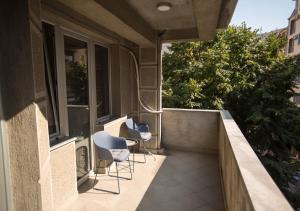 a balcony with two chairs and a table on a building at Three Bedroom Apartment Near City Center in Skopje