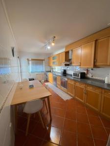 a kitchen with wooden cabinets and a wooden table at Apartment Castelo Branco - Portugal in Castelo Branco