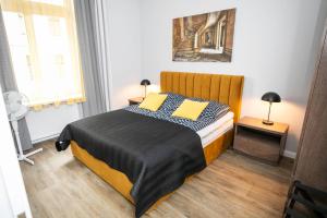 a bedroom with a bed with two yellow pillows at Gwiezdny Pył in Toruń