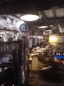 a bar with a counter and a clock on the wall at Locanda Cantina Di Bacco in San Marino