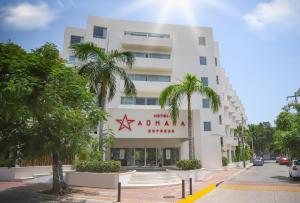a white building with palm trees in front of it at Adhara Express in Cancún