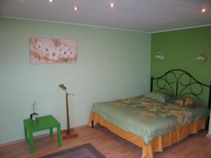 キーウにあるHotel Service Predslava on Antonovicha streetの緑の壁、ベッド付きのベッドルーム1室