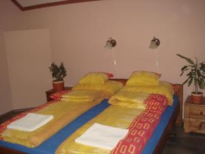 A bed or beds in a room at Platán Panzió