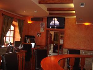 a dining room with a table and a tv on the wall at Platán Panzió in Nagyszénás