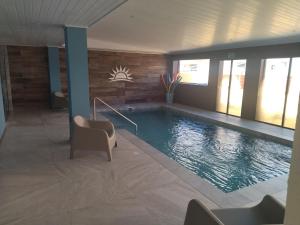 a large swimming pool in a room with chairs at Hotel City Piriápolis in Piriápolis