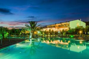 a large swimming pool in a resort at night at Xenios Anastasia Resort & Spa in Nea Skioni