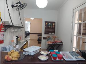 una cocina con una mesa con plátanos y otros alimentos en Canema Pousada, en Arraial do Cabo