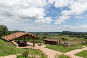 a gazebo with a table and a bench at Csenger Vendégházak in Mátraverebély +35 photos