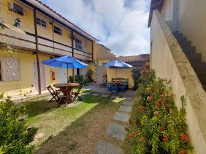 un patio con mesas y sombrillas en Canema Pousada, en Arraial do Cabo