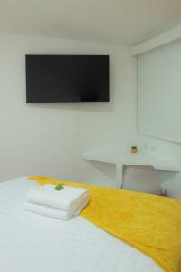 a bedroom with a bed with a tv on the wall at Very Special Place Apto in Guatemala +8 photos