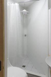 y baño blanco con ducha y aseo. en Very Special Place Apto en Guatemala