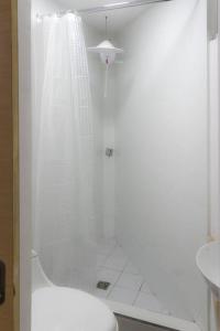 a white bathroom with a shower and a toilet at Very Special Place Apto in Guatemala