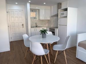 uma pequena cozinha com uma mesa branca e cadeiras em FANTASTIC APARTMENT. LOS CRISTIANOS. FREE WIFI. em Los Cristianos